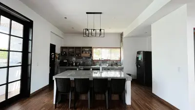 a kitchen with a table with chairs and a refrigerator at Cieneguilla Dreams in Cieneguilla