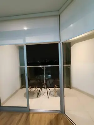 a room with glass walls with a table and a view at Departmento Campo de Marte in Lima