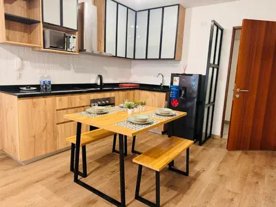 a kitchen with a wooden table and a black refrigerator at MONTERRICO POLO APARTS #20 - DEPARTAMENTO DELUXe FRENTE EMBAJADA USA in Lima