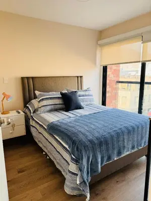 a bedroom with a bed with a blue blanket at MONTERRICO POLO APARTS #20 - DEPARTAMENTO DELUXe FRENTE EMBAJADA USA in Lima