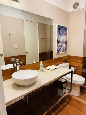 a bathroom with a sink and a toilet and a mirror at MONTERRICO POLO APARTS #20 - DEPARTAMENTO DELUXe FRENTE EMBAJADA USA in Lima