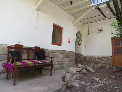a wooden bench sitting in the corner of a room at La Casa de Abril Cusco in Cusco