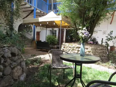 a table and chairs with a vase of flowers on it at La Casa de Abril Cusco in Cusco