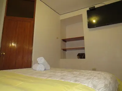 a bedroom with a bed with two towels on it at La Casa de Abril Cusco in Cusco
