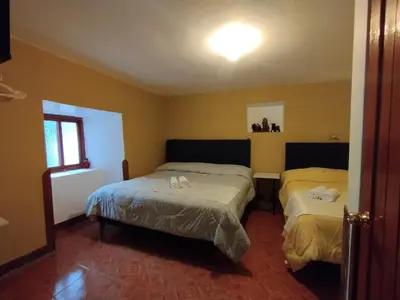 two beds in a room with yellow walls at La Casa de Abril Cusco in Cusco