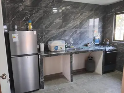 a kitchen with a stainless steel refrigerator and a sink at La Casa de Anni Departamento 3 in Oxapampa