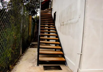 a set of wooden stairs leading up to a building at La Casa de Anni Departamento 2 in Oxapampa