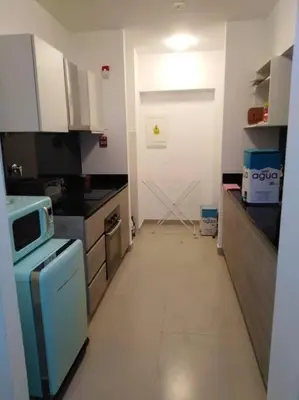 a small kitchen with a stove and a refrigerator at Amplio, Bonito , Silencioso y céntrico en Miraflores in Lima