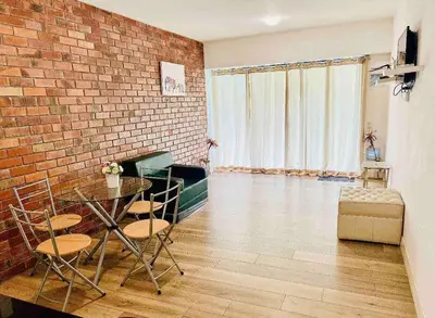 a living room with a glass table and a brick wall at Amplio, Bonito , Silencioso y céntrico en Miraflores in Lima
