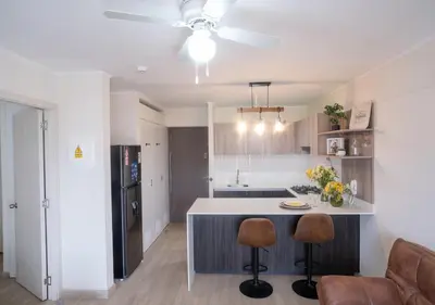 a kitchen with a kitchen island with two bar stools at Estreno en barranco BR1 in Lima