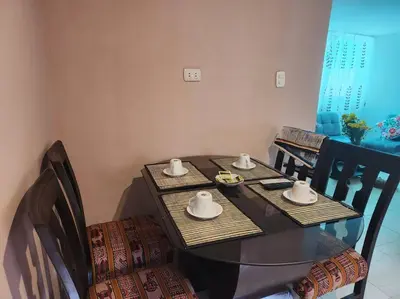 a dining table with two chairs and a table with cups and saucers at Casa Mirador San Blas II in Cusco
