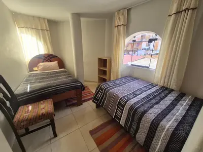 a bedroom with two beds and a window at Casa Mirador San Blas II in Cusco