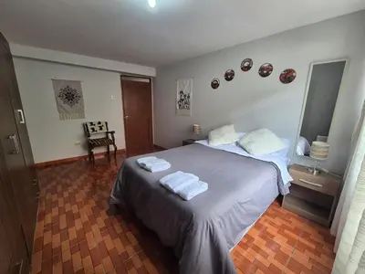 a bedroom with a bed with two towels on it at MaKePal Guest House in Cusco