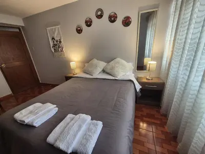 a bedroom with a bed with two towels on it at MaKePal Guest House in Cusco