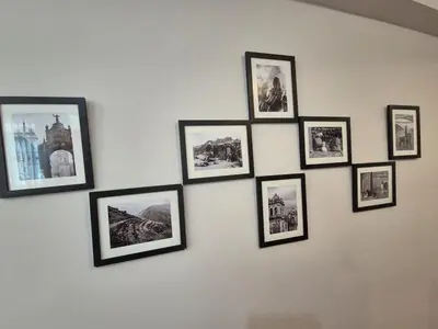 a group of framed pictures on a wall at MaKePal Guest House in Cusco