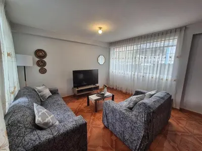 a living room with two couches and a flat screen tv at MaKePal Guest House in Cusco