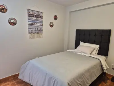 a bedroom with a large bed and a window at MaKePal Guest House in Cusco