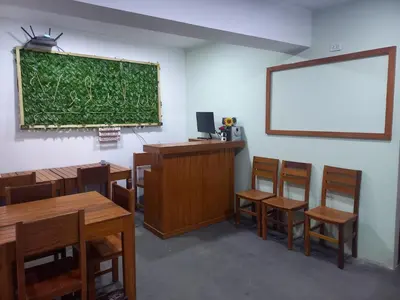a classroom with tables and chairs and a chalkboard on the wall at Hospedaje velilu in Ica