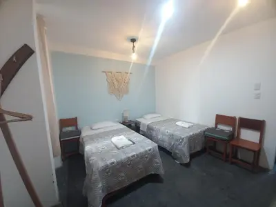 a room with two beds and a chandelier at Hospedaje velilu in Ica