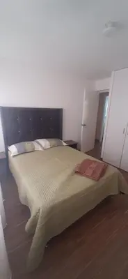 a bedroom with a large bed with a wooden floor at Alojamiento Miraflores 3 habitaciones in Lima