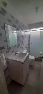 a bathroom with a sink and a toilet and a mirror at Alojamiento Miraflores 3 habitaciones in Lima
