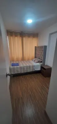 a small bedroom with a bed and a wooden floor at Alojamiento Miraflores 3 habitaciones in Lima