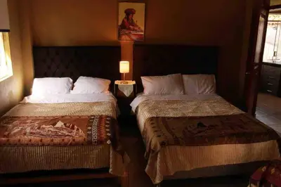 a hotel room with two beds and a lamp at Casa Victoria - Huayllabamba, Urubamba Cusco, Perú in Huayllabamba