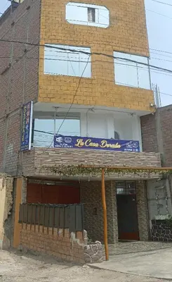 a brick building with a blue sign on it at La casa dorada in Huacho
