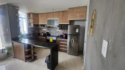 a kitchen with wooden cabinets and a stainless steel refrigerator at Departamento exclusivo ica in Ica