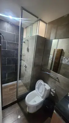 a bathroom with a toilet and a glass shower at Departamento exclusivo ica in Ica