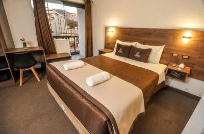 a hotel room with two beds and a window at San Francisco Pardo Hotel in Cusco