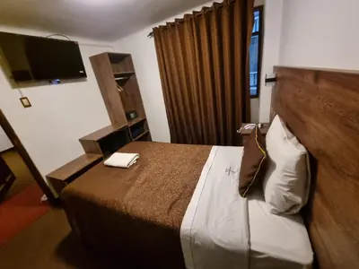 a hotel room with a bed and a flat screen tv at San Francisco Pardo Hotel in Cusco