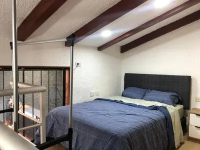 a bedroom with a bed with a blue comforter at Departamento en corazón de Miraflores in Lima