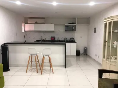 a kitchen with two bar stools and a counter at Departamento en corazón de Miraflores in Lima