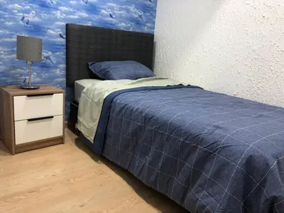 a bedroom with a blue bed with a night stand at Departamento en corazón de Miraflores in Lima