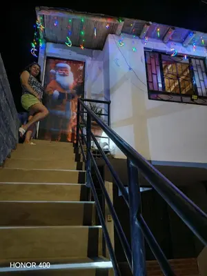a woman sitting on the stairs of a building at Casita de camucha in Chincha Baja