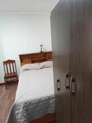a bedroom with a bed and a wooden cabinet at Habitaciones en la Casa de Dora, 4to y 5to piso in Ayacucho