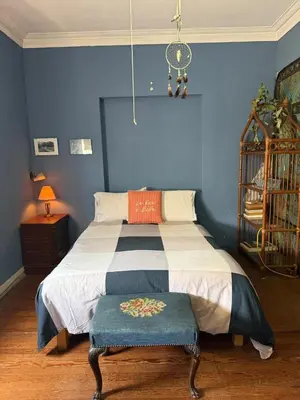 a bedroom with a bed with a blue wall at Miraflores Moonlight B&B in Lima