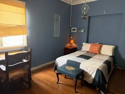 a blue bedroom with a bed and a chair at Miraflores Moonlight B&B in Lima