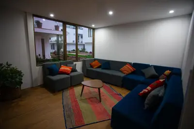a living room with a blue couch and a table at MUJU hotel by Ämak in Urubamba