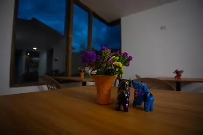 two figurines on a table with a vase of flowers at MUJU hotel by Ämak in Urubamba
