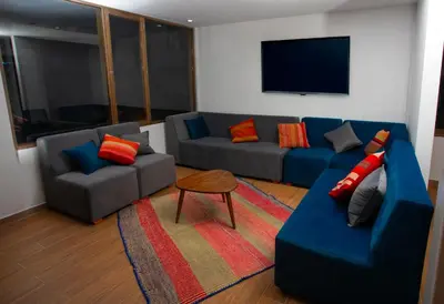 a living room with two couches and a tv at MUJU hotel by Ämak in Urubamba