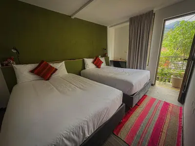 a hotel room with two beds and a window at MUJU hotel by Ämak in Urubamba