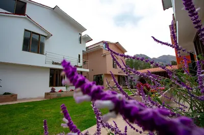a house with purple flowers in the yard at MUJU hotel by Ämak in Urubamba