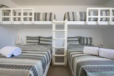 two beds in a room with bunk beds at Sotavento Beach Homes by Vibrant in Paracas
