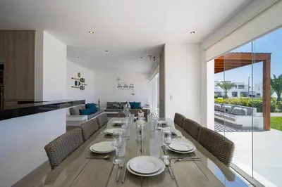 a dining room with a long table and chairs at Sotavento Beach Homes by Vibrant in Paracas