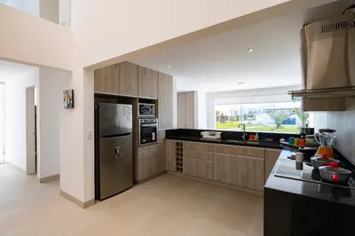 a kitchen with a stainless steel refrigerator and a window at Sotavento Beach Homes by Vibrant in Paracas
