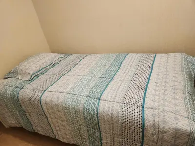 a bed with a blue and white comforter in a bedroom at TOWEr2 in Lima