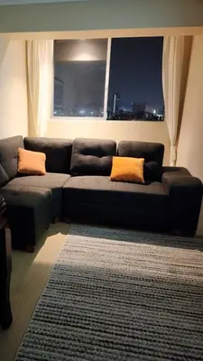 a living room with a black couch with orange pillows at TOWEr2 in Lima