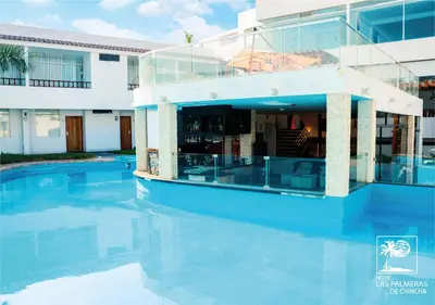 a house with a swimming pool in front of a building at Qallwa Chincha in Chincha Alta